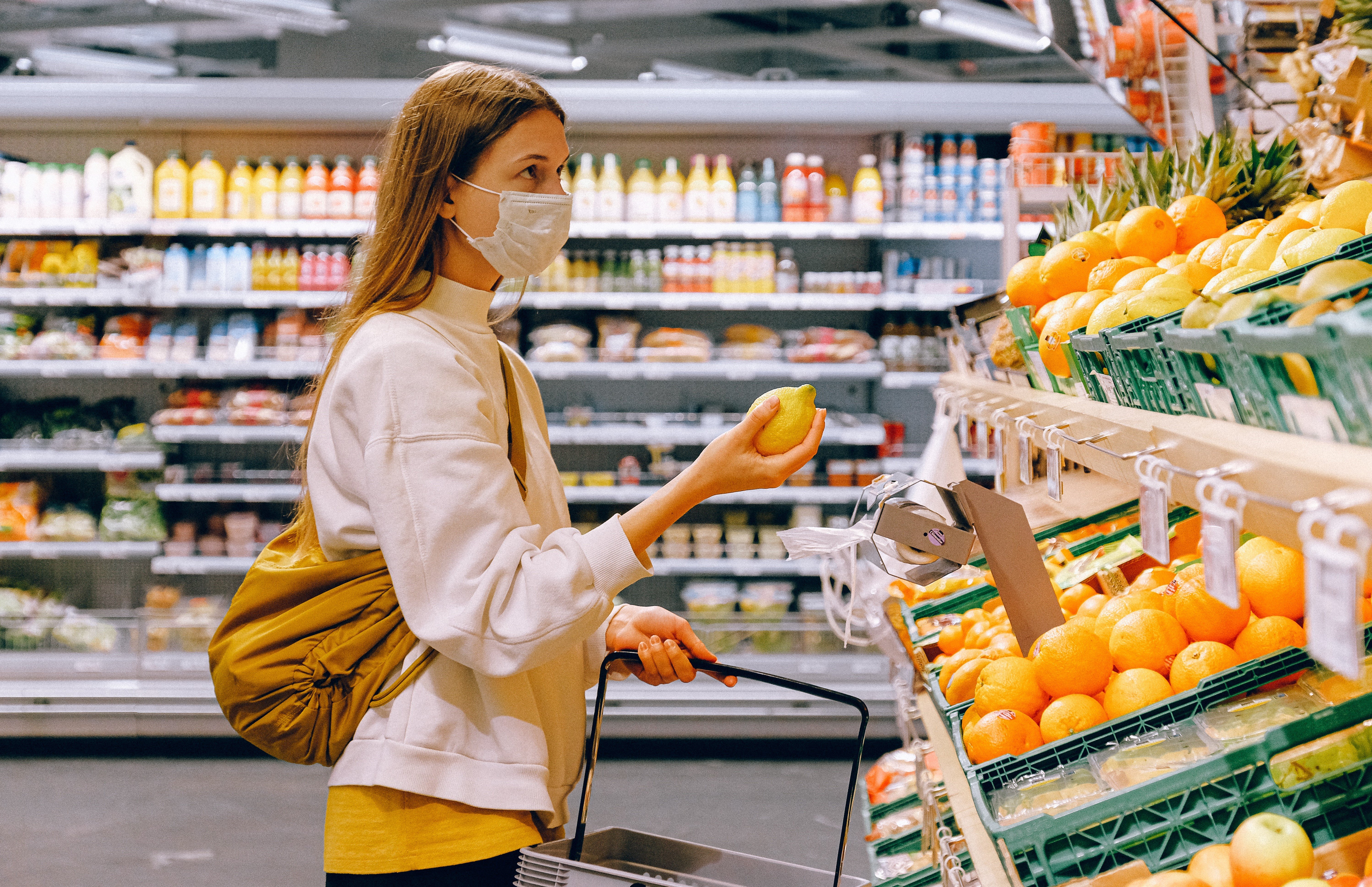 woman-in-yellow-tshirt-and-beige-jacket-holding-a-fruit